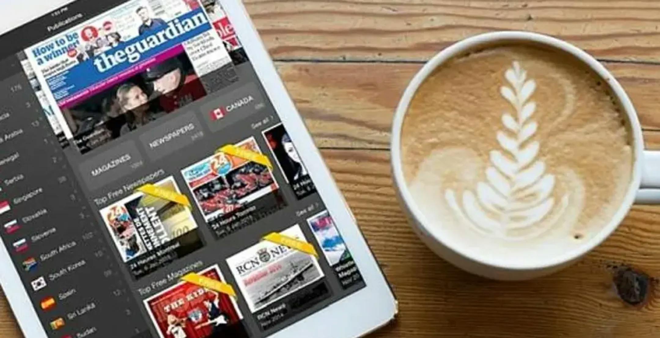 Digital avis på nettbrett og kaffikopp ved sida av